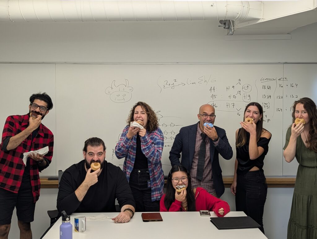 Gokcumen Lab members at a lab meeting by the whiteboard