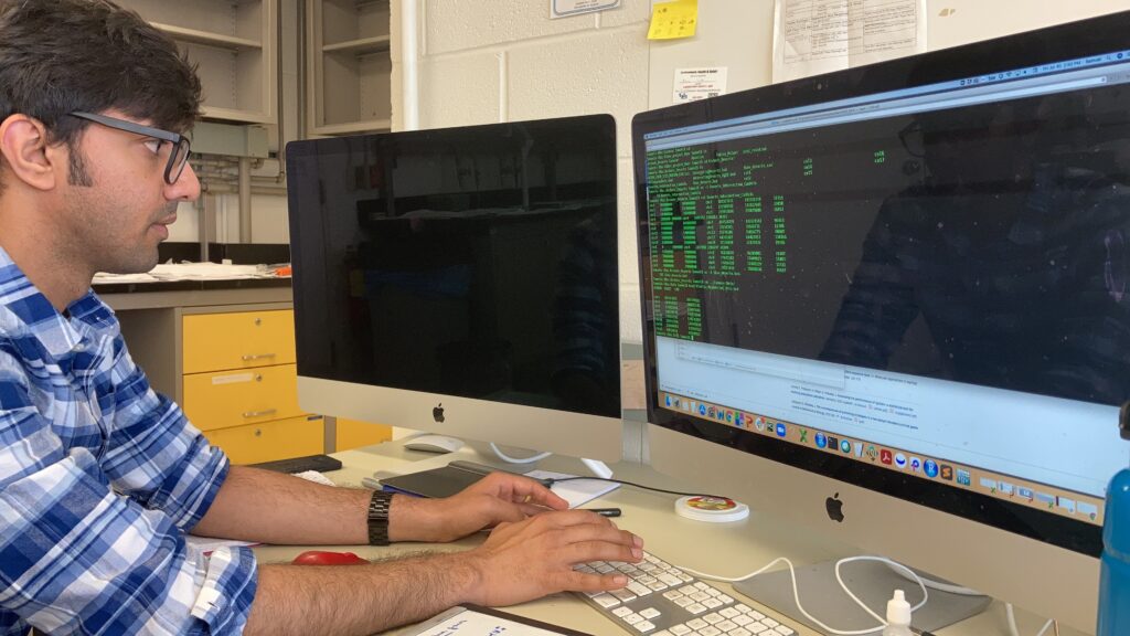 A lab member reviewing genomic data on a computer screen