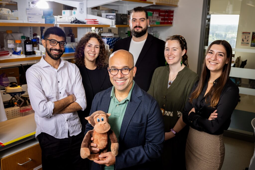 Omer Gokcumen with lab members in the lab